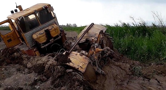 Кировец в грязи по самую раму